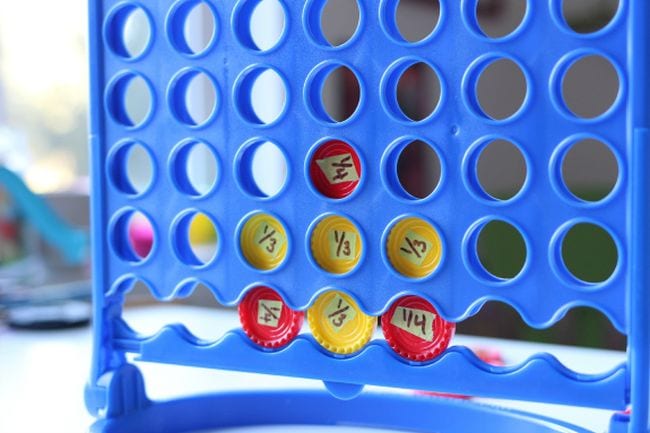 A Connect 4 game is set up with red and yellow discs signifying fractions as an example of fraction games and activities