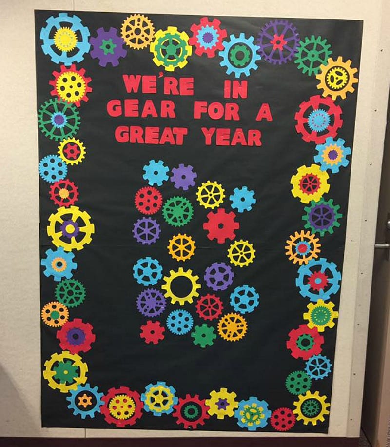 Bulletin board decorated with paper gears, reading "We're in gear for a great year"