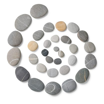 Stones are laid out from largest to smallest in a swirl pattern. (earth day crafts)