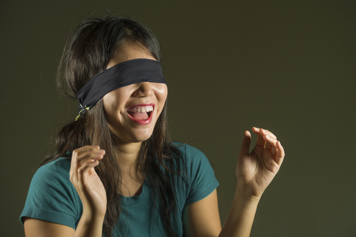 Name games can involve blindfolds. A teenage girl is seen with a blindfold on.