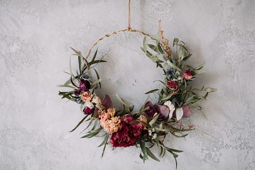 A wreath is shown made from gold wire and dried flowers. 