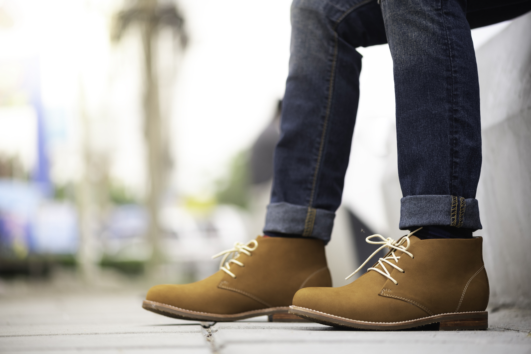 Fashion model wearing blue jeans and brown ankle boots.