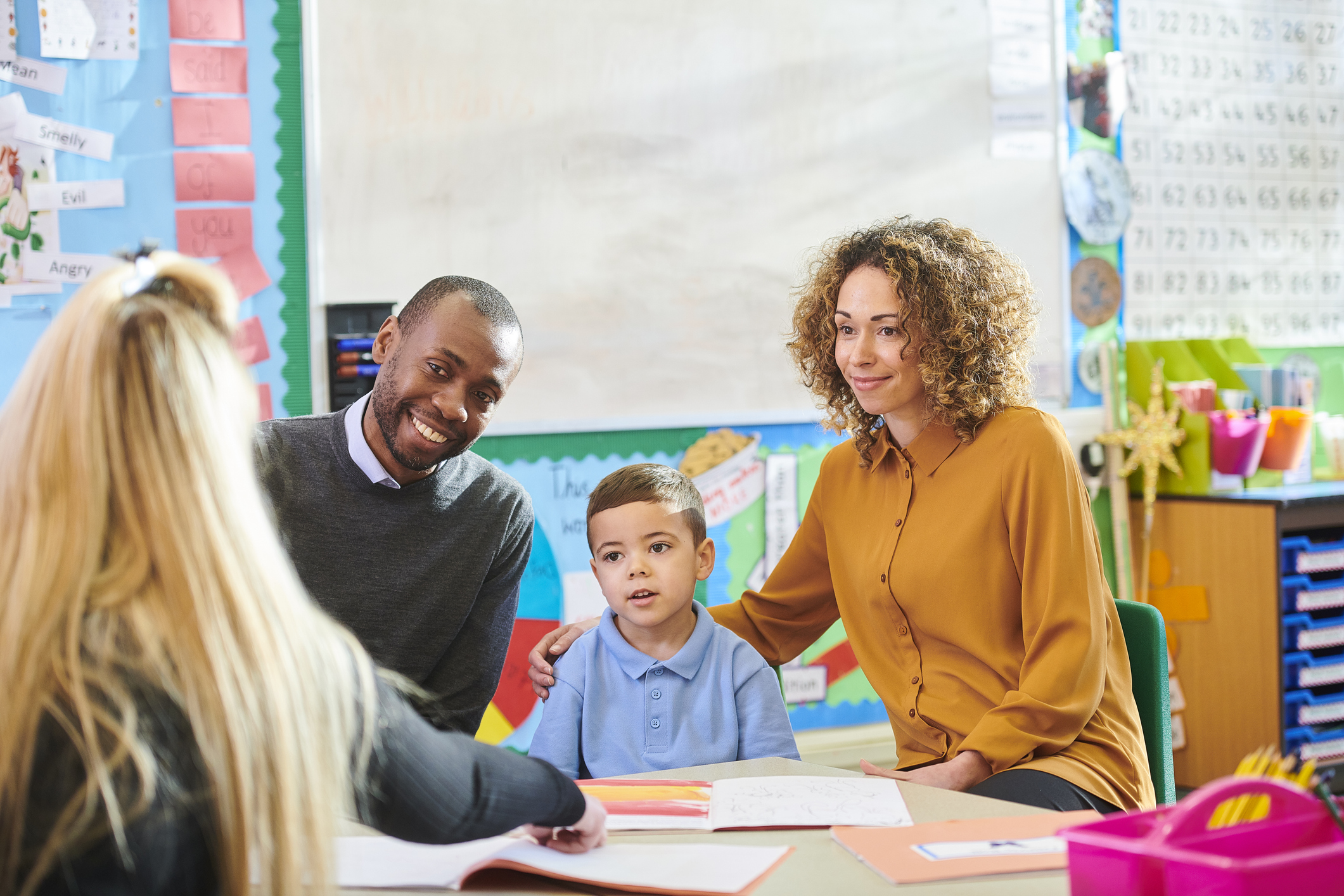Parents, teachers, and students gathered in a school room