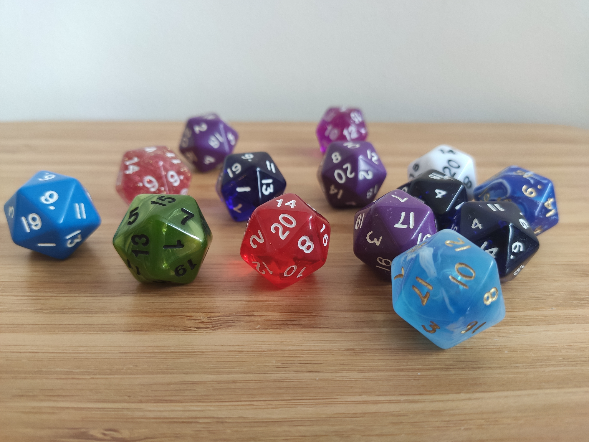 Close-up of a fourteen twelve sided RPG plastic die rolled on light wooden table in different colours. Use for your hobby, board games, or role playing games sites and articles.
