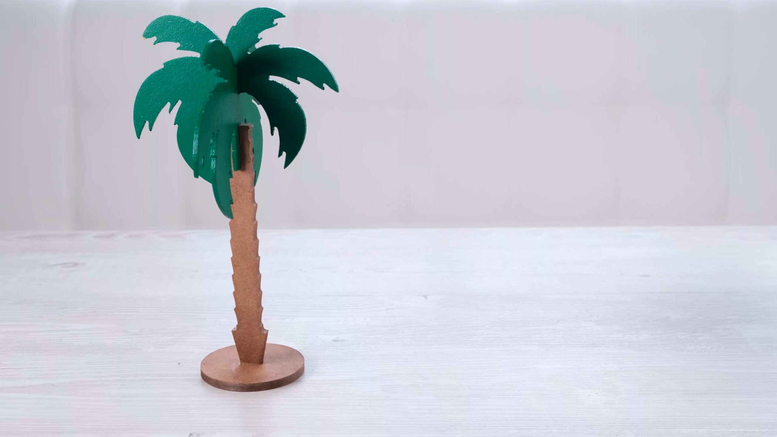 artificial palm tree and rainbow soap bubbles on a white wooden table.