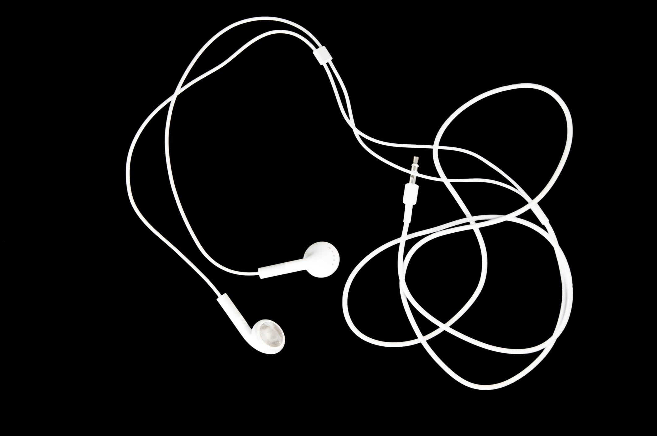 Brilliant white earbuds on a black background with copy space.