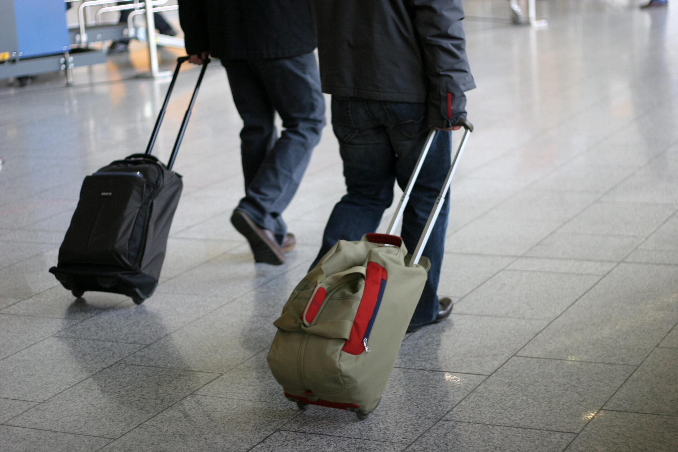 Two people pulling rolling bags