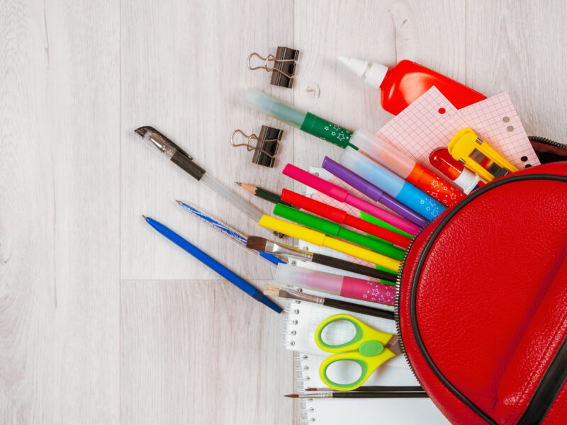 Stationery for studying against the background of a student's backpack close-up