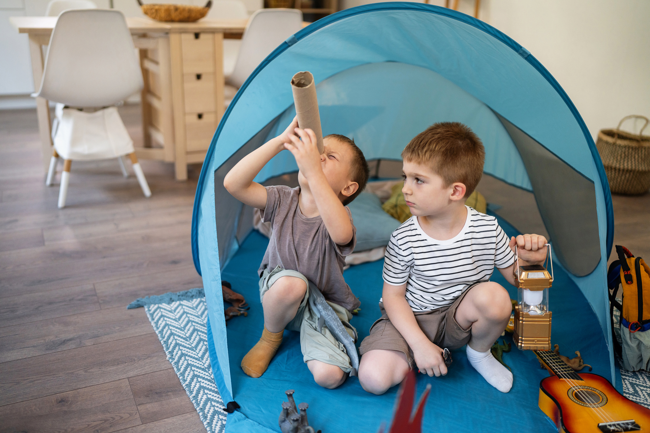 Two little brothers camping inside their home.
