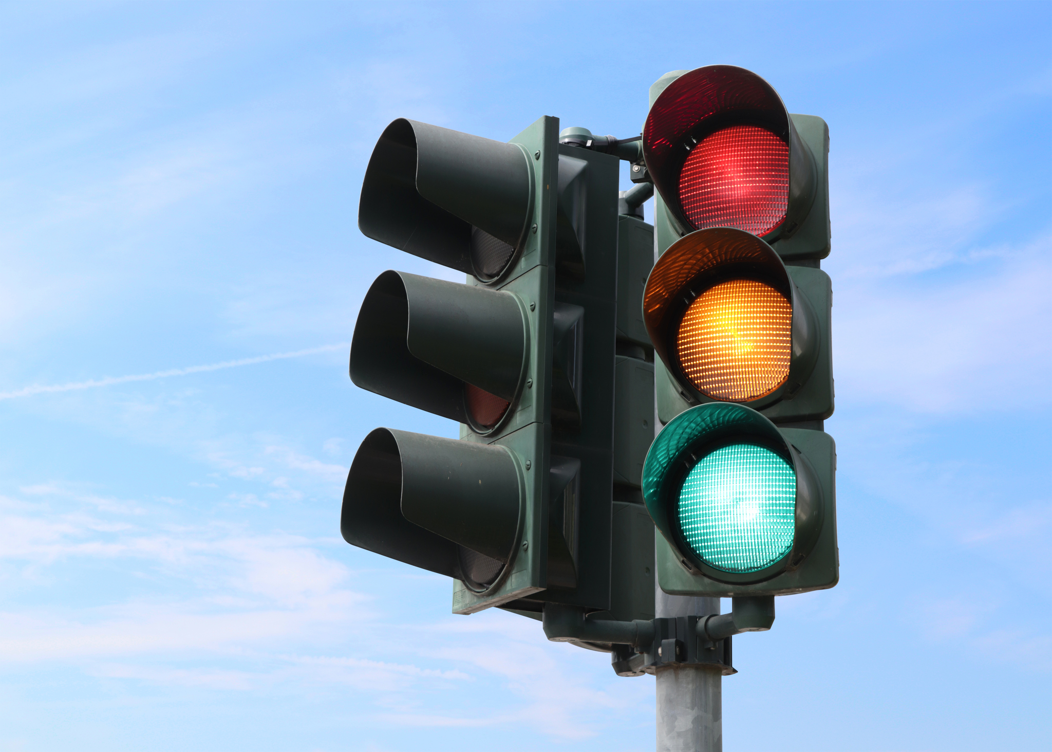 Traffic light isolated in the sky with all the lights on.