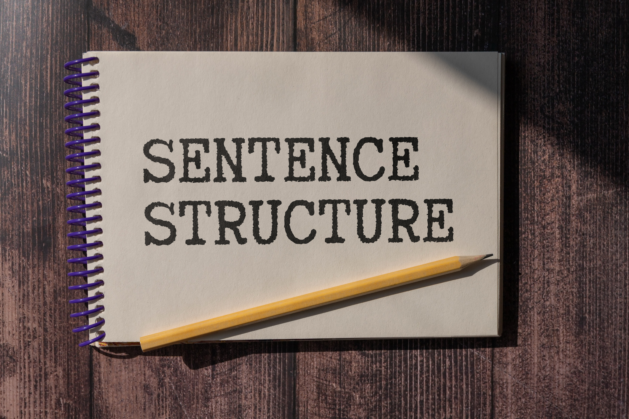 SENTENCE STRUCTURE - words in a white notepad on the background of a laptop with pencils. Business concept