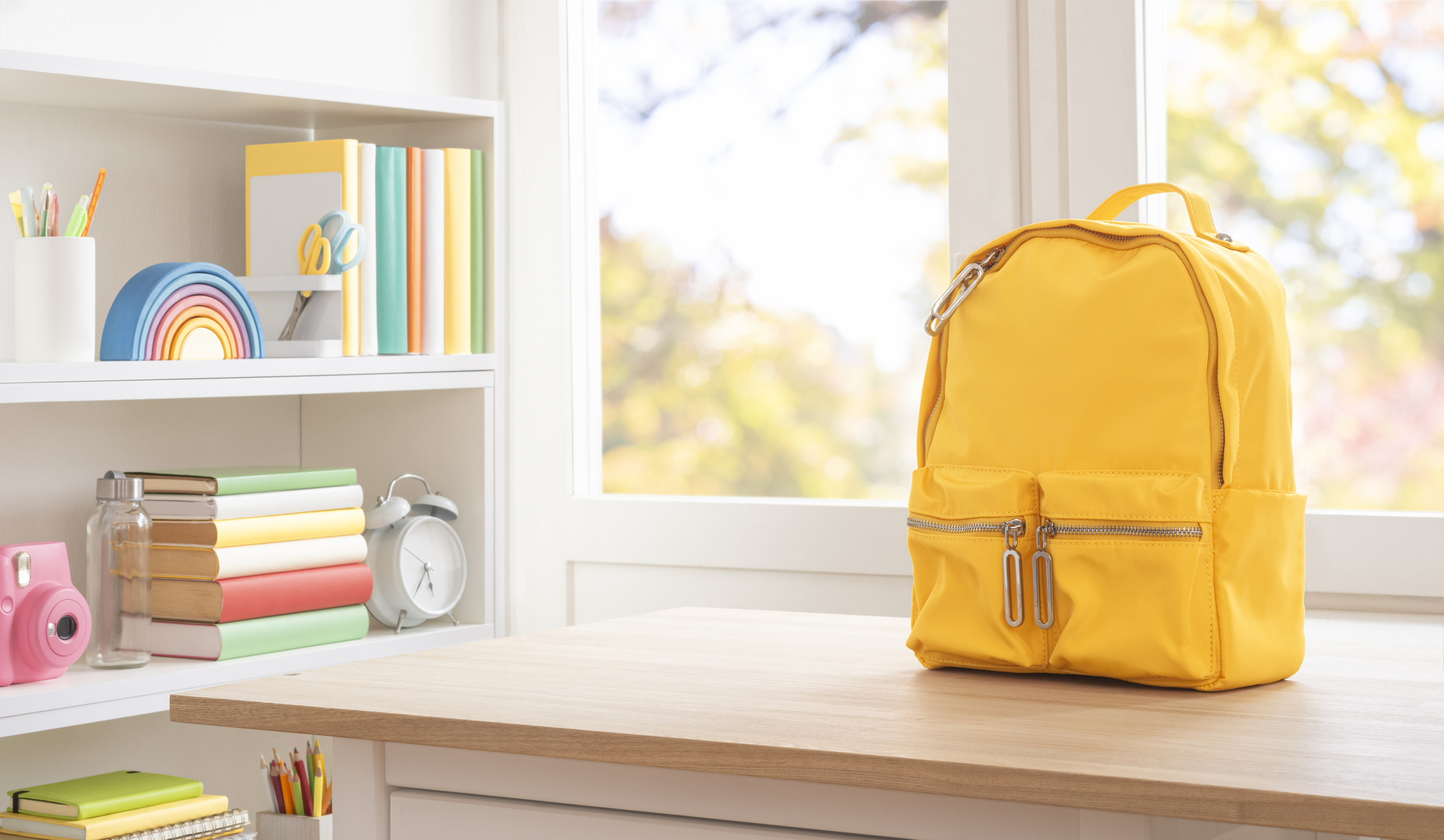 School supplies and yellow schoolbag on wooden table with copy space. Original work - no AI used