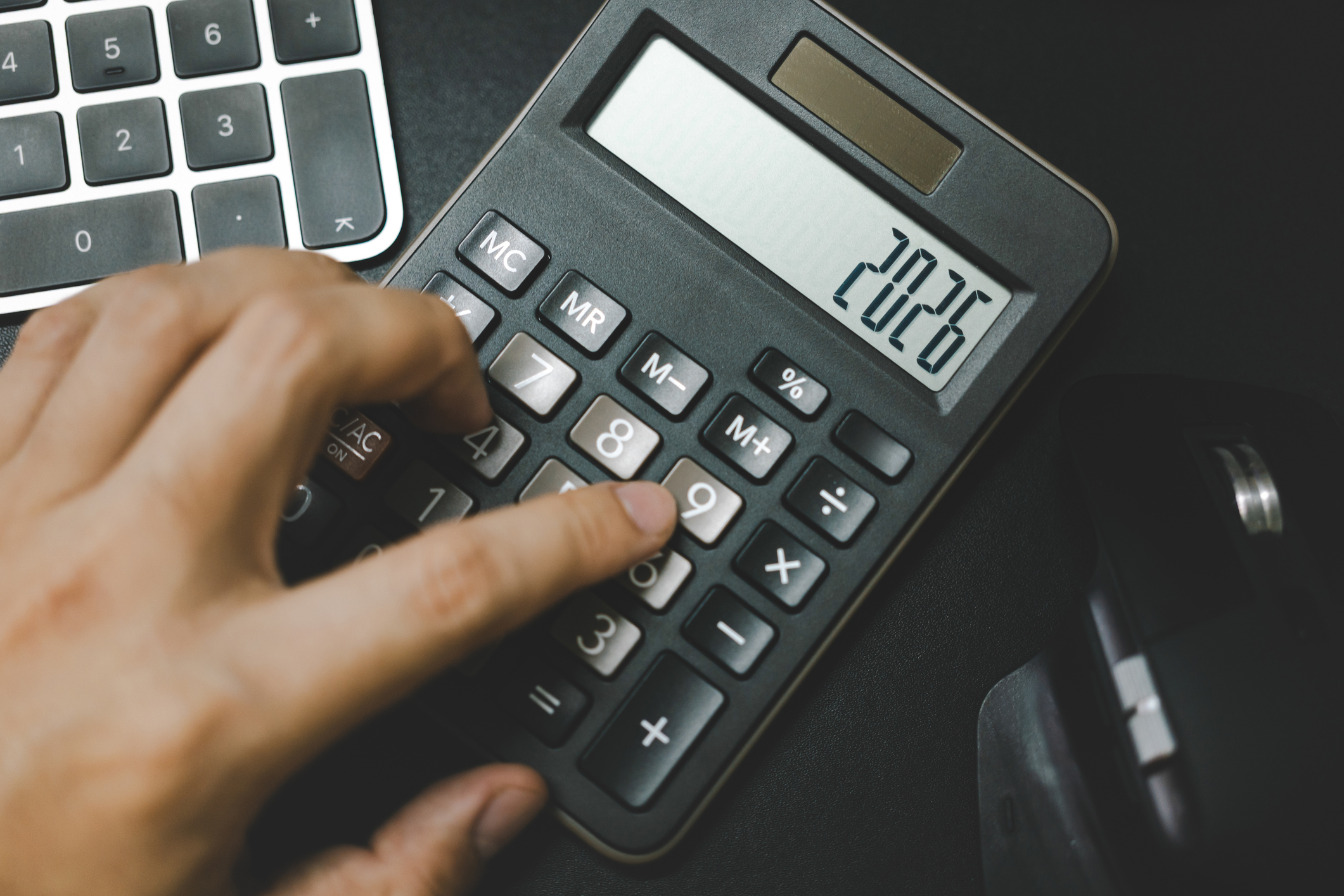 Person using a simple black calculator