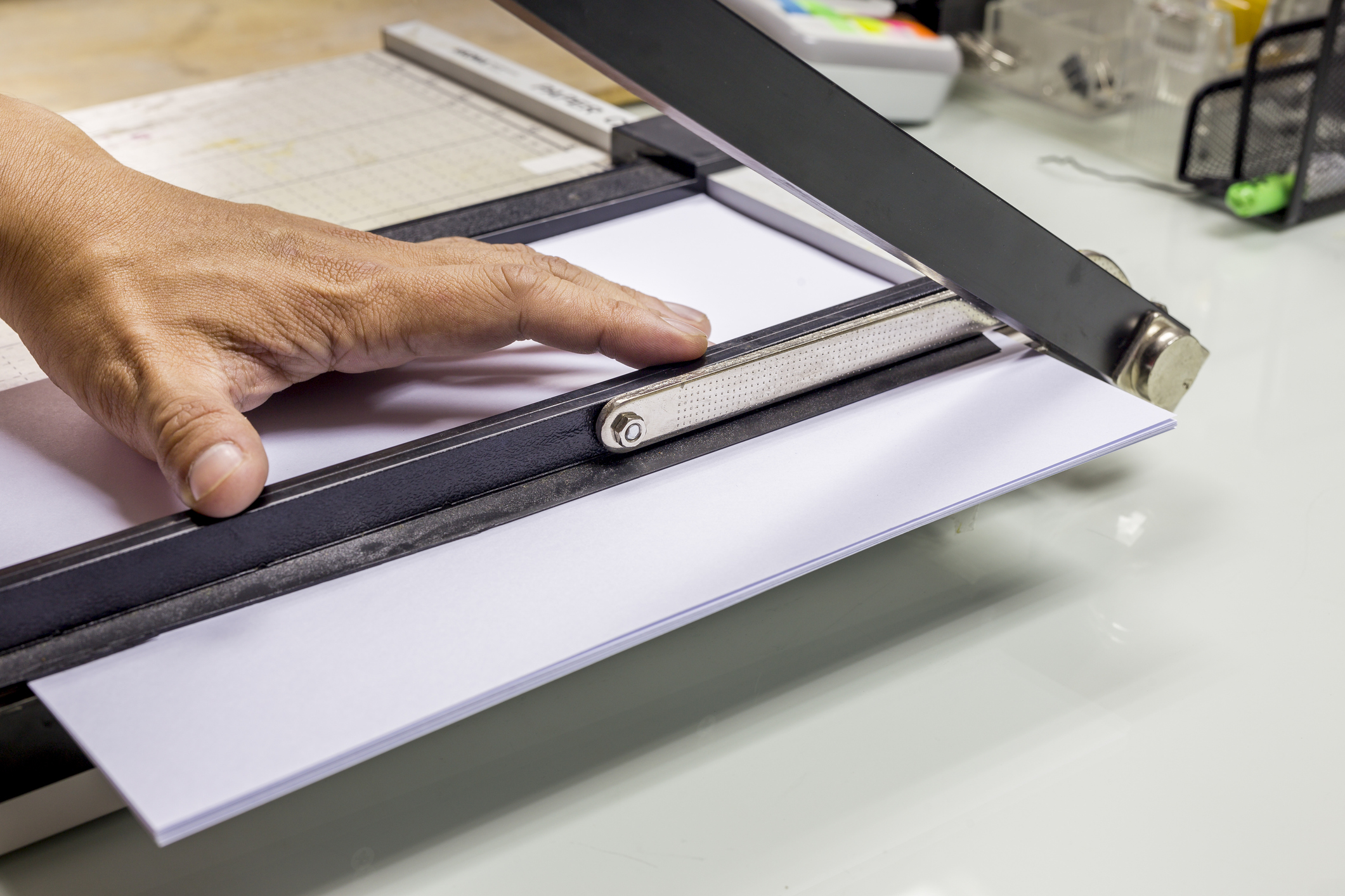 Person using a desktop paper cutter