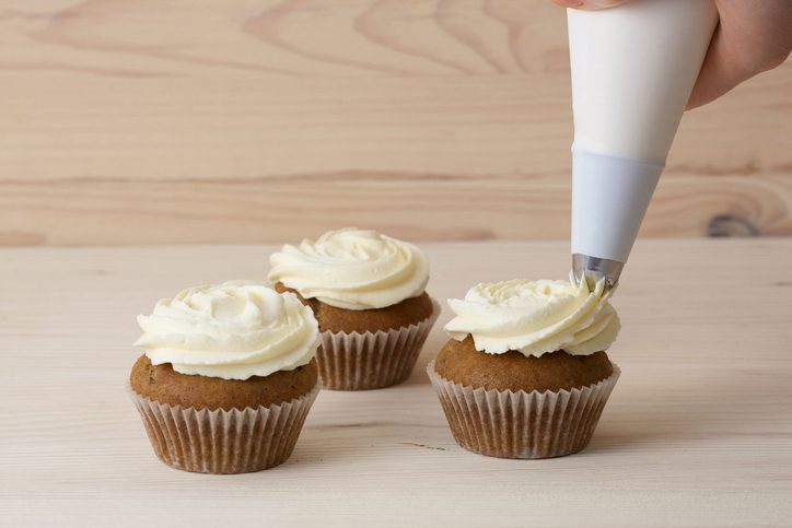 Frosting is shown being applied to cupcakes (art careers)