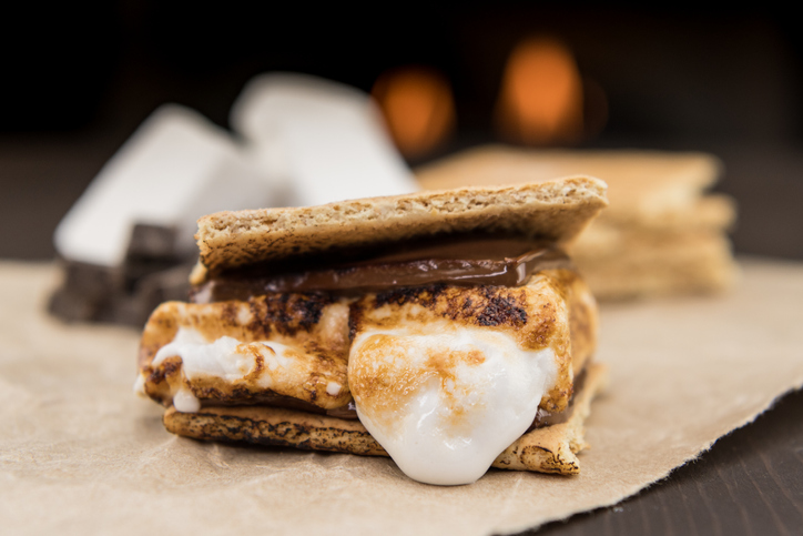 A smore is shown made from graham crackers, marshmallows, and chocolate bars.