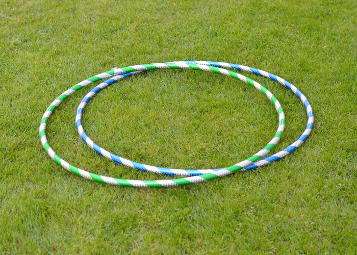Cooperative games for kids can be played with hula hoops like these two shown on the grass.