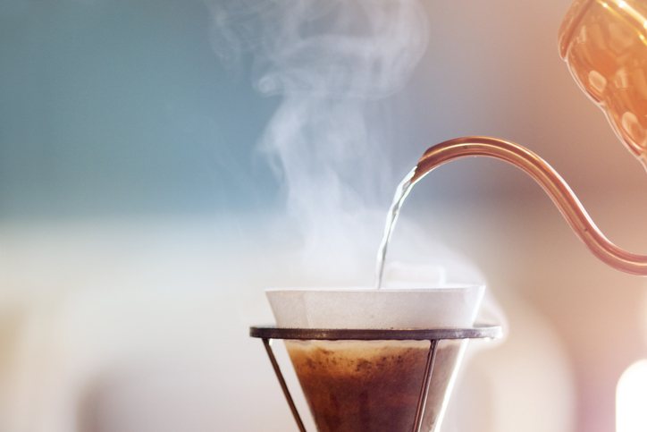 Drip coffee, barista pouring water on coffee ground with filter