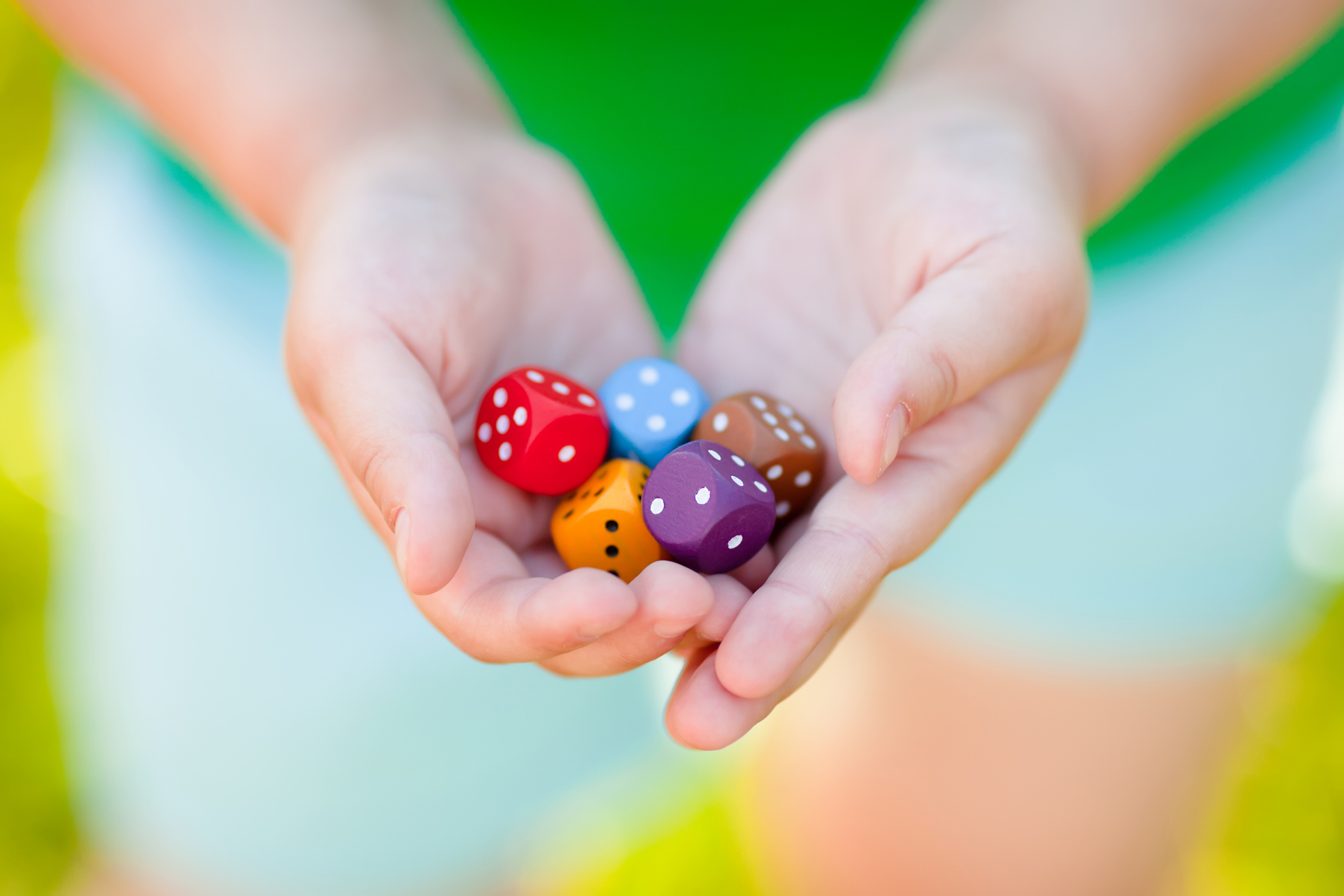 Mixed color dices in child's hands.