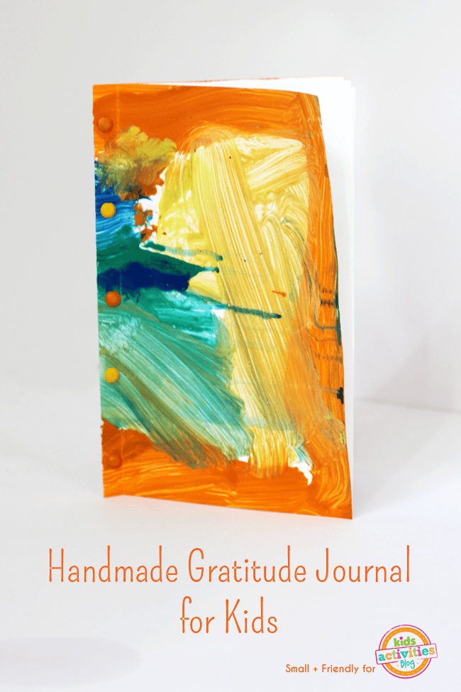 The front of a journal is shown with an abstract painting on the cover of this easy art project for kids.