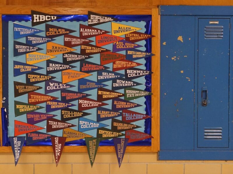 A bulletin board is covered in pennants with the names of historically black colleges and universities. 
