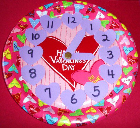 A clock is made from a Valentine's Day paper plate with little hearts representing each number (Valentine's Day Crafts for kids)