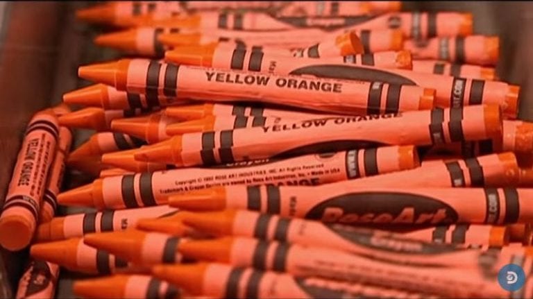 A pile of yellow orange crayons taken as a screenshot from how things are made videos