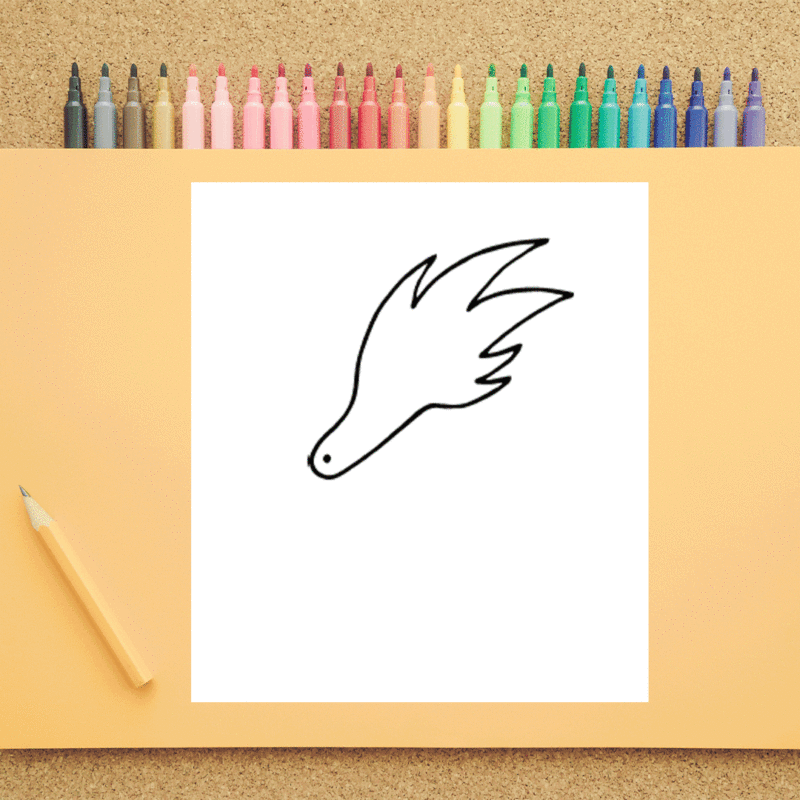 A white piece of paper has an outline of a dragon's head on it. It is on a peach background with a pencil. There are marker tips seen in the background.