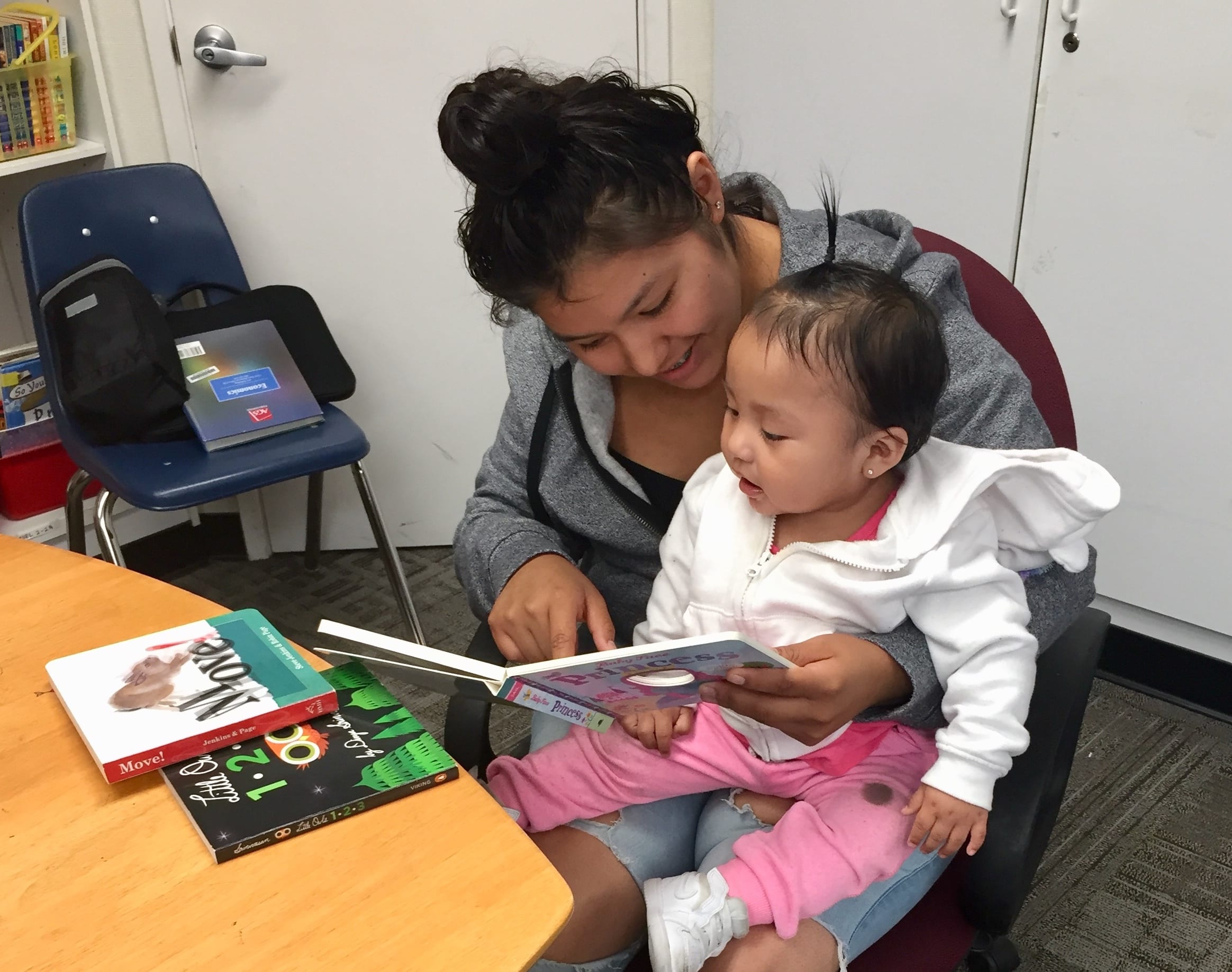 high school student reading to a baby