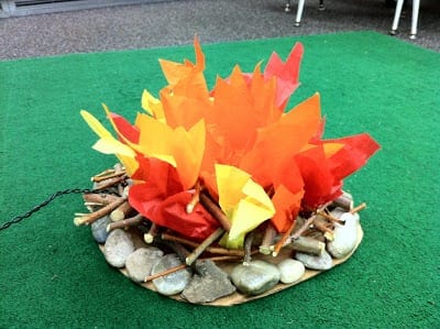 A pretend campfire made of tissue paper, sticks, and rocks is shown. 