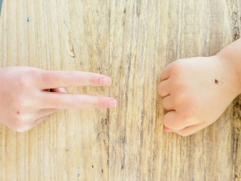 an image of two students participating in a game of rock, paper, scissors as a team building activitiy