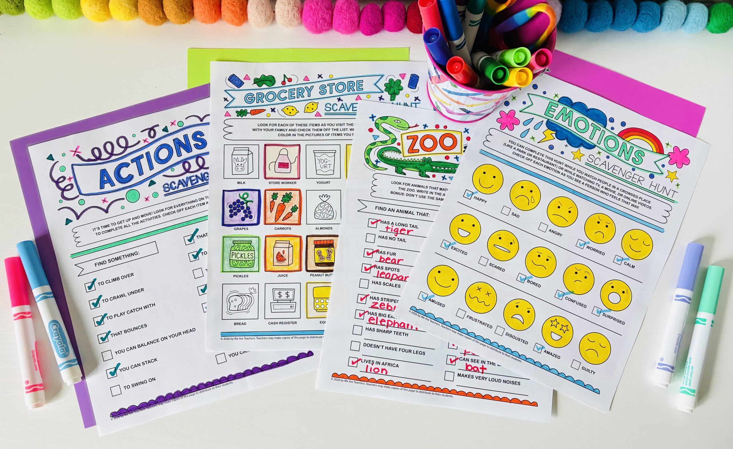 an image of four completed printable scavenger hunts for kids with markers on a desk
