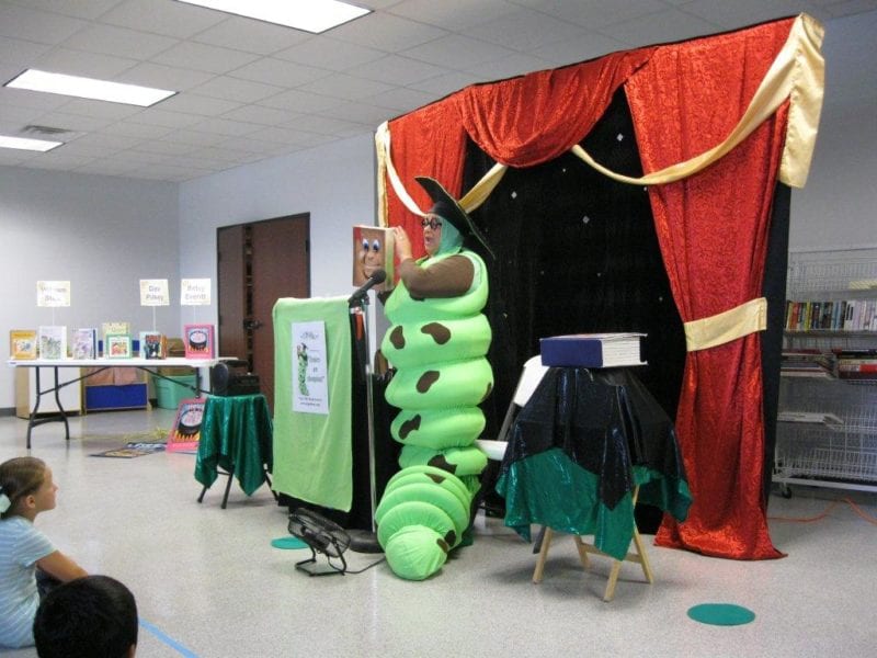 Woman dressed up as caterpillar giving a speech