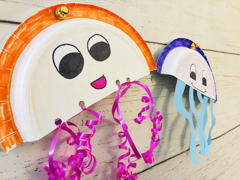 Ocean Activities for Kids paper plate jellyfish ocean craft hanging on a bulletin board