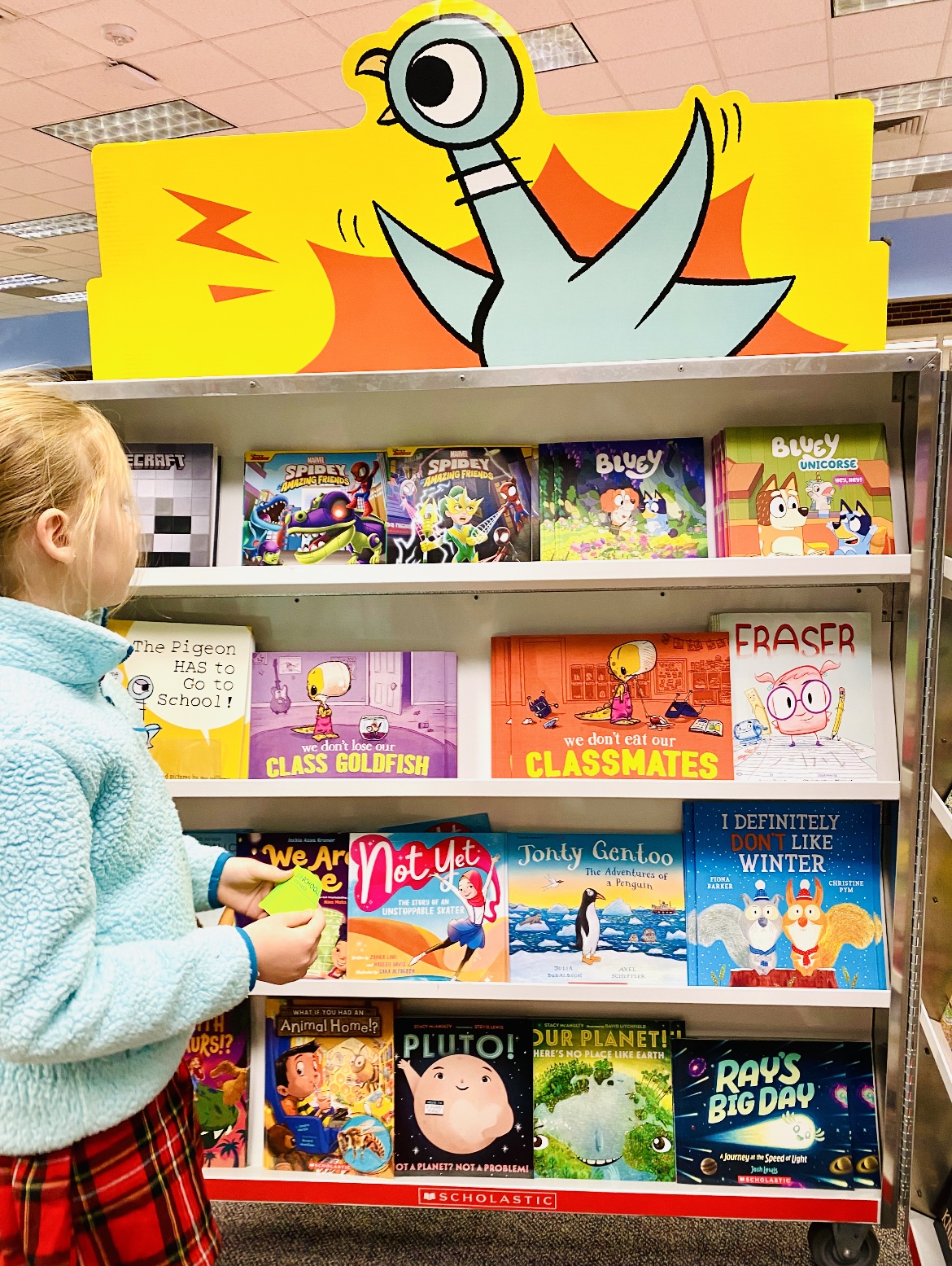Read Across America Activities an image of a student browsing books at a school book fair