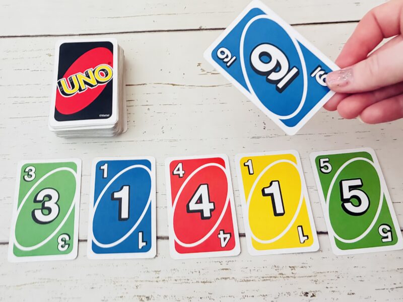 a pi day card game being played with Uno cards