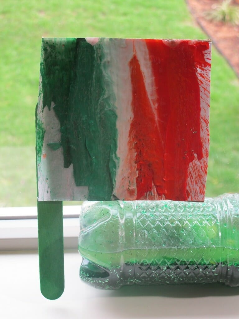 an Irish flag made from melted crayons and a craft stick, as an example of St. Patrick's Day activities 