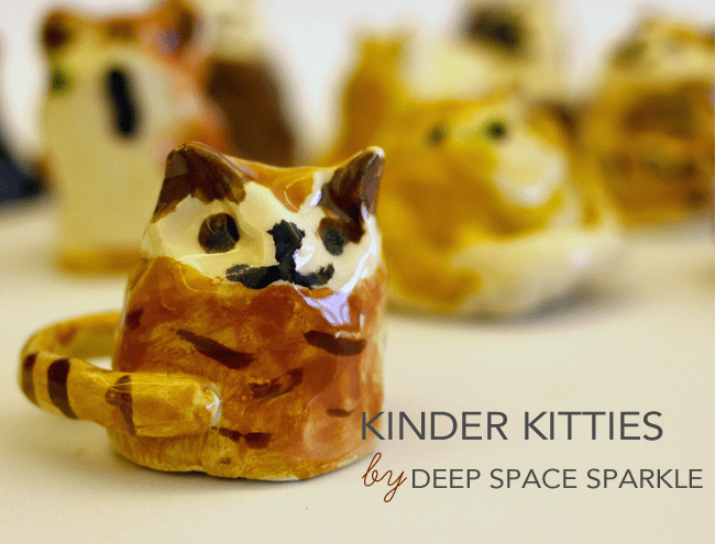 Simple clay cat figurines; text reads Kinder Kitties by Deep Space Sparkle