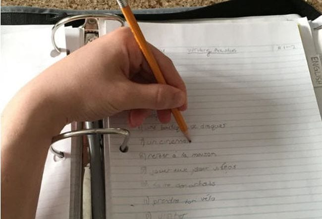 Left-handed student writing with a pencil