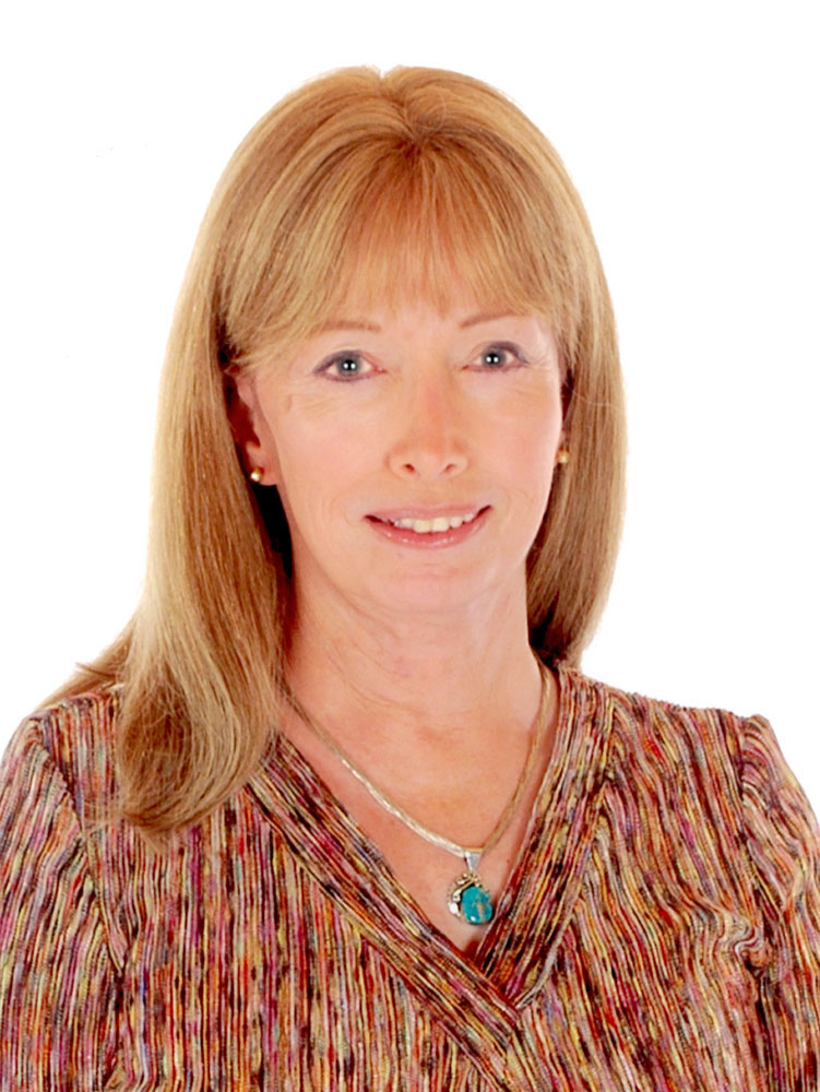 A woman with long red hair is seen from the mid chest up in a photograph.