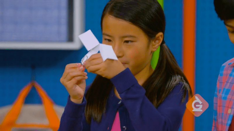 A young student holds up a DIY seed model