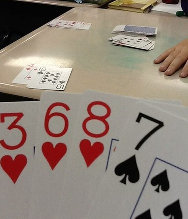 Student holding playing cards