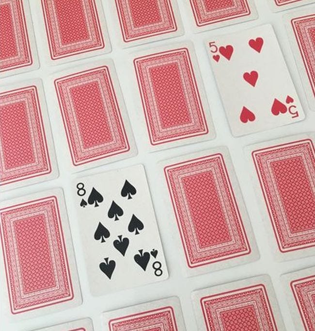 Playing cards laid face down, with a five and eight face up (Math Card Games)