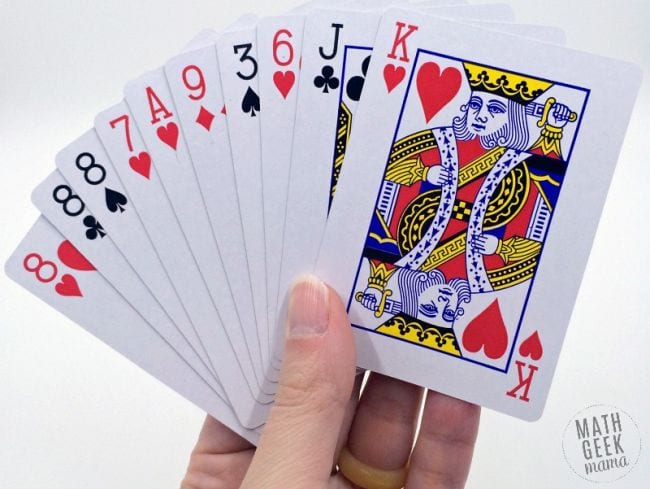 Student holding a selection of playing cards (Math Card Games)