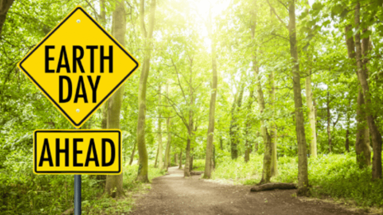 Forest with "Earth Day Ahead" street sign