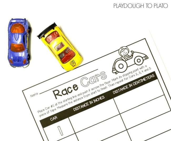 A worksheet titled Race Cars sits next to two matchbox cars, one blue and one yellow