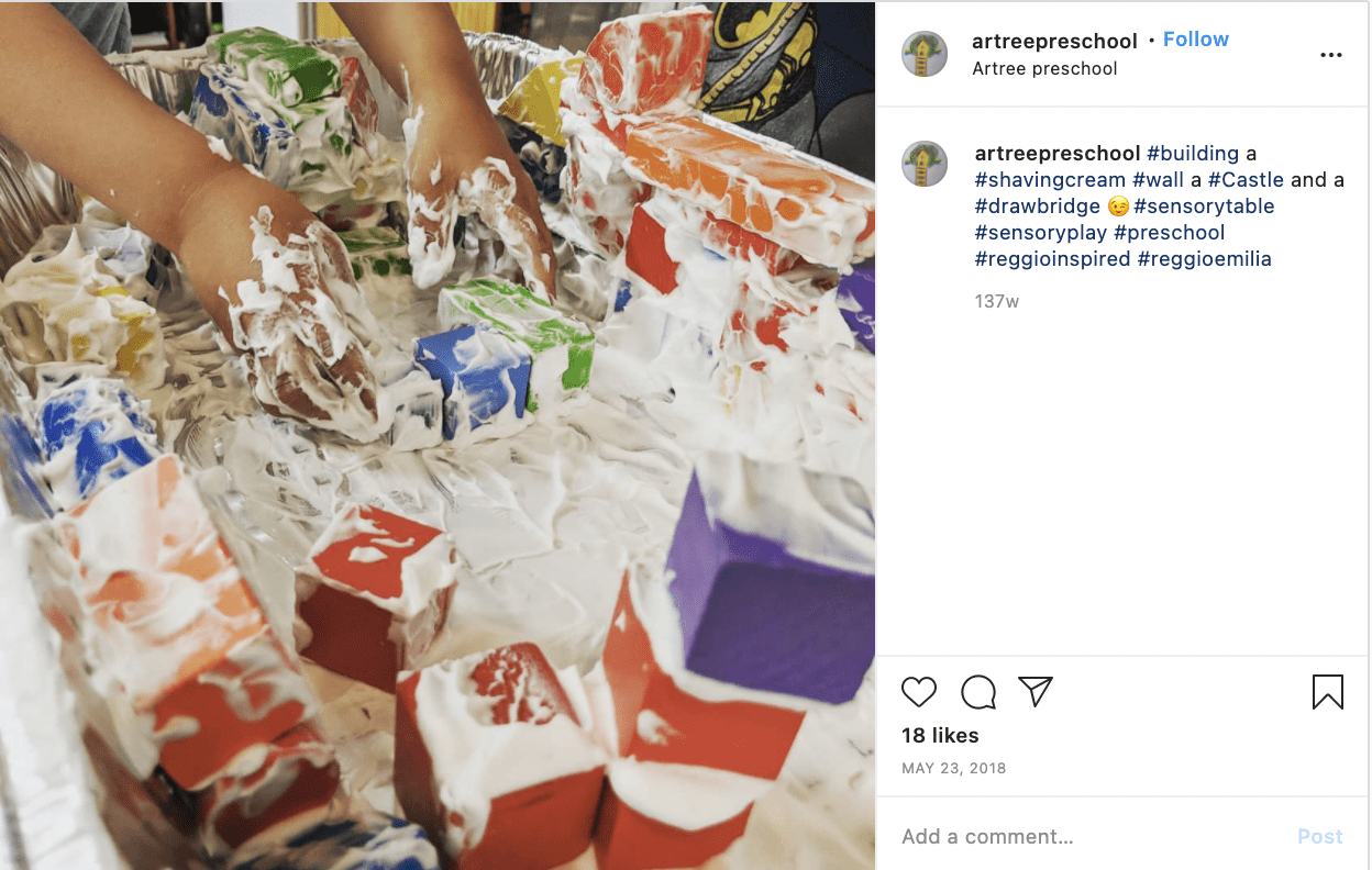 A student's hands holding blocks covered in shaving cream building towers and walls