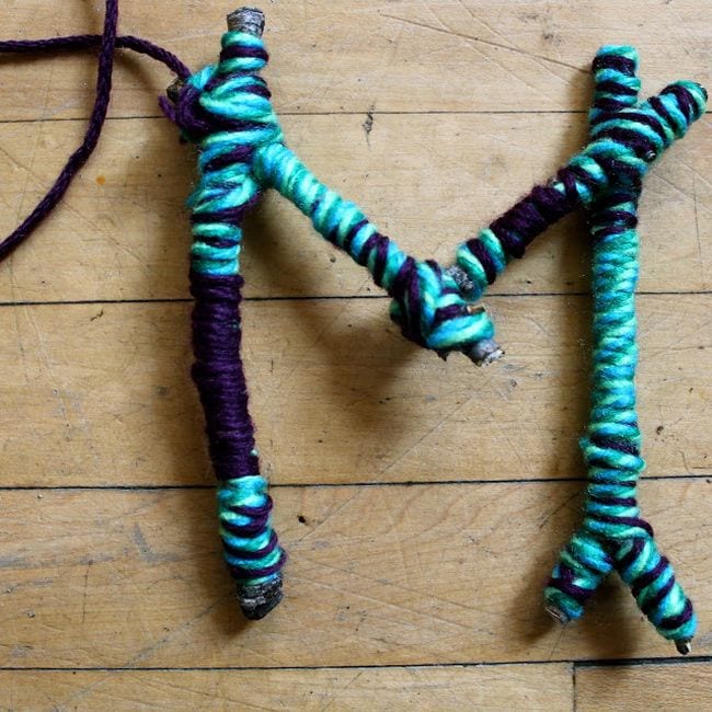 The letter M made from yarn-wrapped twigs