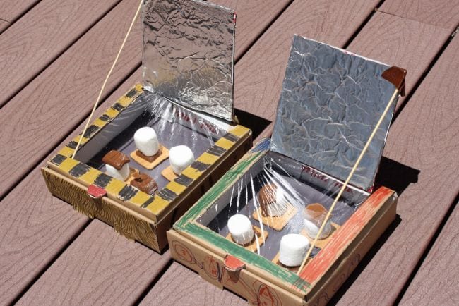 Outdoor science activities can involve the sun like these solar ovens built from pizza boxes with s'mores cooking inside