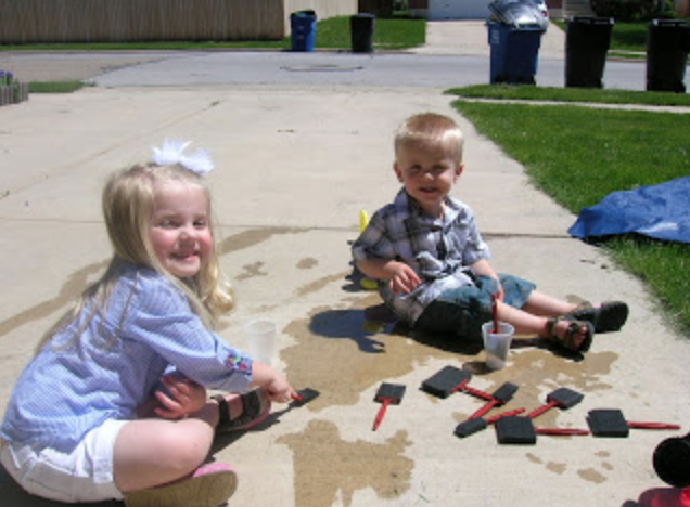 Kids painting driveway with water